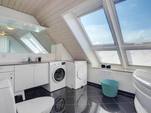 a bathroom with a washing machine and a sink at Holiday Home Langsom - 100m from the sea in Western Jutland by Interhome in Havneby