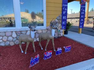 Due statue di cervi finti davanti a una casa. di Antlers Motel a Chester