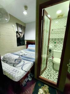 1 dormitorio con cama y baño con espejo. en United Co-Operate Guest House (7/F), en Hong Kong