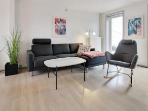 a living room with a couch and a table and two chairs at Apartment Mirija - 2-3km from the sea in Western Jutland by Interhome in Havneby