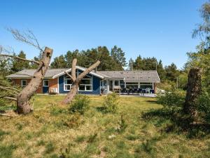 a house with two uprooting trees in the yard at Holiday Home Cordula - 800m from the sea in Western Jutland in Mølby
