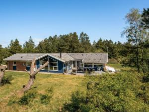 a home with a blue house in a field at Holiday Home Cordula - 800m from the sea in Western Jutland in Mølby
