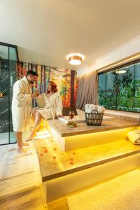 a man and woman in a bath tub in a room at Caminho das Pedras Pousada de Charme in Campos do Jordão