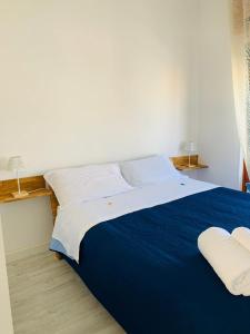 a bedroom with a blue and white bed with two pillows at BLU HOUSE in Marina di Modica