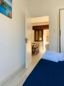 a bedroom with a blue bed and a dining room at BLU HOUSE in Marina di Modica