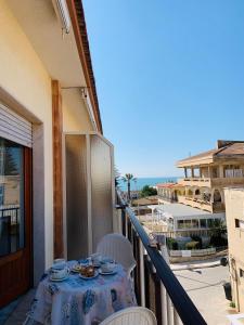 a table on a balcony with a view of the ocean at BLU HOUSE in Marina di Modica