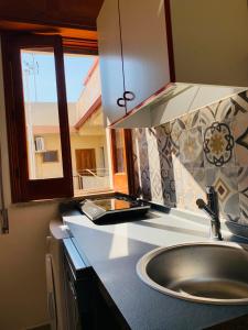 Una encimera de cocina con un fregadero y una ventana. en BLU HOUSE, en Marina di Modica 9 fotos más