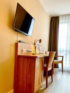 a hotel room with a desk with a television on the wall at Businesshotel Berlin in Berlin