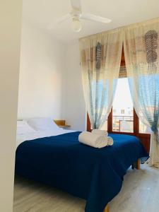 a bedroom with a blue bed with two towels on it at BLU HOUSE in Marina di Modica