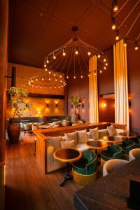ein Restaurant mit Stühlen, Tischen und einem großen Kronleuchter in der Unterkunft Hotel Coco in Bogotá