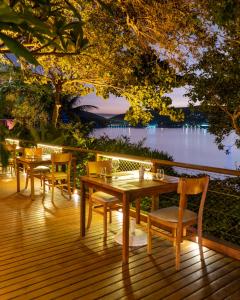 a table and chairs on a deck with a view of the water at Insólito Boutique Hotel & Spa in Búzios +202 photos