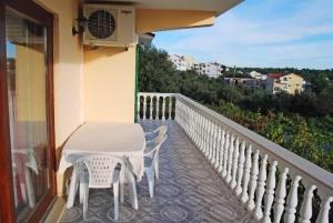 a balcony with a table and chairs on a building at Apartments Mirko in Seget Vranjica