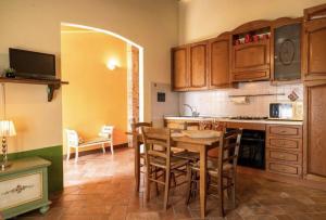 cocina con mesa de madera y comedor en Il Vecchio Mulino Toscana, en Radicondoli