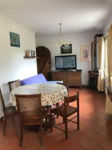uma sala de estar com uma mesa e cadeiras e uma televisão em Villa Berio Quattro - Miguel em Villa Viani