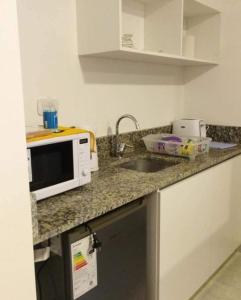 encimera de cocina con microondas y fregadero en La Moradita en Belén de Escobar