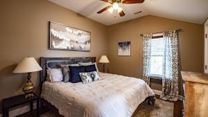 a bedroom with a bed with a ceiling fan and a window at Cheerful 5-bedroom w/Screened Patio, Sleeps 10 in the heart of Fremont! in Fremont