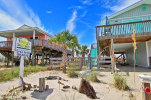 ein Haus am Strand mit einem Schild davor in der Unterkunft Dream Catcher in Gulf Shores
