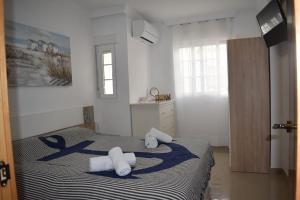 ein Schlafzimmer mit einem Bett mit Handtüchern darauf in der Unterkunft La casita de ¨Pueblo Rocio¨ in Torre del Mar