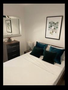 a bedroom with a large white bed with blue pillows at Luxurious 2 bedroom apartment in Canary Wharf in London
