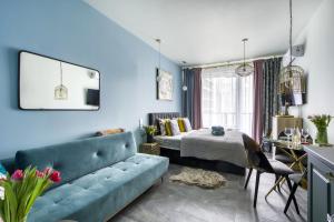salon z niebieską kanapą i łóżkiem w obiekcie Apartamenty MetroPark Krzemieniecka-Lux w Warszawie