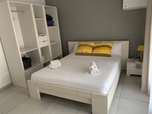 Un dormitorio con una cama blanca con almohadas amarillas y amarillas en La Duchesse - T3 Duplex à St-Gilles-Les-Bains en Saint-Gilles-les-Bains