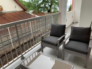 - deux chaises assises sur le balcon d'une maison dans l'établissement La Duchesse - T3 Duplex à St-Gilles-Les-Bains, à Saint-Gilles les Bains