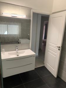 a white bathroom with a sink and a mirror at La Duchesse - T3 Duplex à St-Gilles-Les-Bains in Saint-Gilles les Bains +9 photos