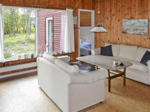 a living room with two white couches and a table at Holiday Home Dorreth - 800m from the sea in Western Jutland by Interhome in Mølby