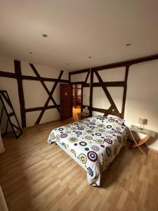 um quarto com uma cama e piso em madeira em La Grenouille em Turckheim