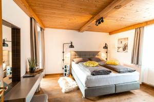 een slaapkamer met een bed in een kamer met houten plafonds bij Ferienhaus Hetzenauer in Kössen