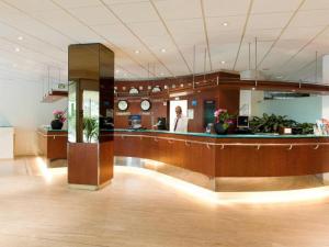 un vestíbulo con una mujer de pie en una habitación en Aparthotel XV Porte Versailles 2P 4 Pers Parking, en París