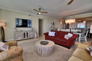 sala de estar con sofá rojo y mesa en Mustique 602, en Gulf Shores