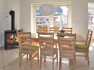 jadalnia ze stołem, krzesłami i kominkiem w obiekcie Holiday Home Harriette - 100m from the sea in Western Jutland by Interhome w mieście Havneby