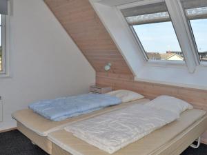 łóżko w pokoju z 2 oknami w obiekcie Holiday Home Harriette - 100m from the sea in Western Jutland by Interhome w mieście Havneby