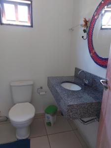 a bathroom with a toilet and a sink and a mirror at Chale Trilha Das Aguas in Rio de Contas