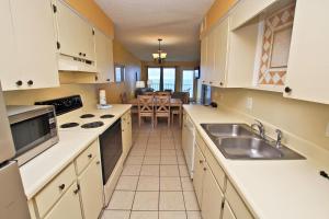 une cuisine avec des placards blancs et une salle à manger dans l'établissement Island Shores 457, à Gulf Shores