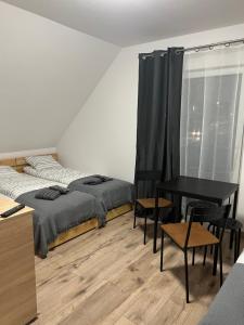 a bedroom with two beds and a table with chairs at Rzut beretem od gondoli in Szczyrk