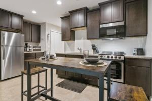 a kitchen with a wooden table and a stainless steel refrigerator at The Den at The Ravines in Middleburg