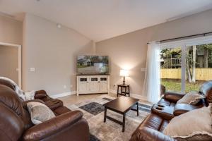 sala de estar con 2 sofás y TV en The Retreat on Florida St, en Fleming Island