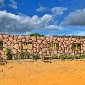 a stone wall with windows in a field at Ecocampingdage in Catimbau