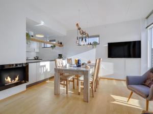 a kitchen and dining room with a table and a fireplace at Apartment Pirkko - 100m from the sea in Western Jutland by Interhome in Havneby