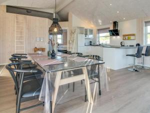 a dining room and kitchen with a glass table and chairs at Holiday Home Minke - 2-2km from the sea in Western Jutland in Bolilmark