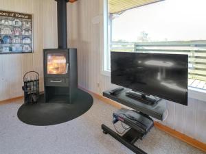 a living room with a flat screen tv and a fireplace at Holiday Home Sara - 2-5km from the sea in Western Jutland by Interhome in Bolilmark