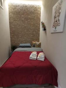 una camera da letto con un letto rosso con due asciugamani di La casa di Adina a Agrigento