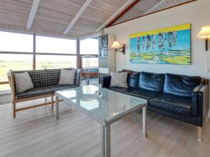 a living room with a couch and a glass table at Holiday Home Alim - 300m from the sea in Western Jutland by Interhome in Lakolk