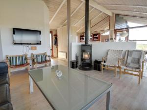sala de estar con mesa de cristal y chimenea en Holiday Home Alim - 300m from the sea in Western Jutland by Interhome, en Lakolk
