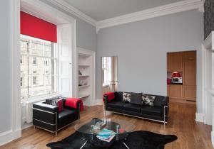 a living room with a black couch and a table at Parliament Sq apt 12 Royal Mile in Edinburgh