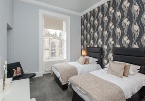 1 dormitorio con 2 camas y ventana en Parliament Sq apt 12 Royal Mile, en Edimburgo