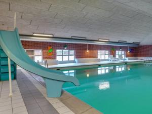 a swimming pool with a slide in a building at Apartment Efraima - 1-7km from the sea in Western Jutland by Interhome in Sønderby