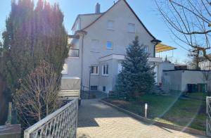 une maison blanche avec un arbre de Noël en face dans l'établissement Ferienhaus-Zirndorf, à Zirndorf